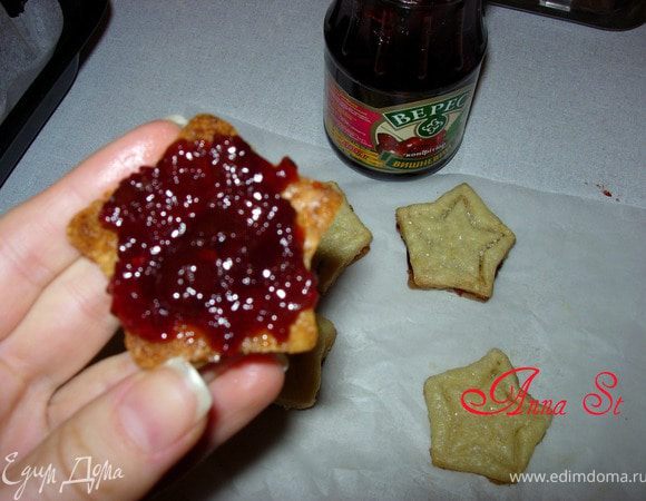 Звёздочки с рисунком сразу же посыпаем оставшимся ванильным сахаром. Даем печенью остыть, а затем звездочки без рисунка намазываем конфитюром и накрываем оставшимся печеньем.