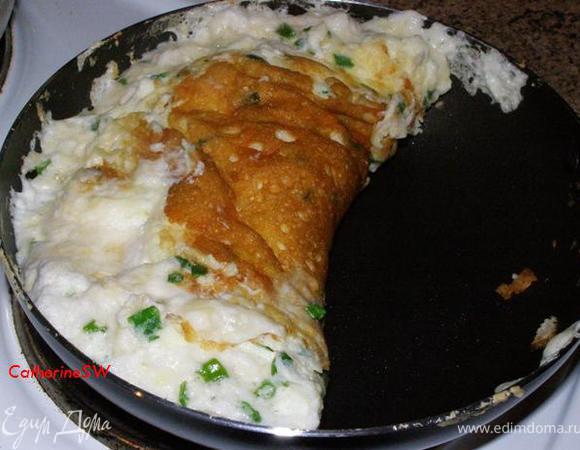 Как только омлет схватится на треть, свернем его пополам и будем жарить с каждой стороны до готовности