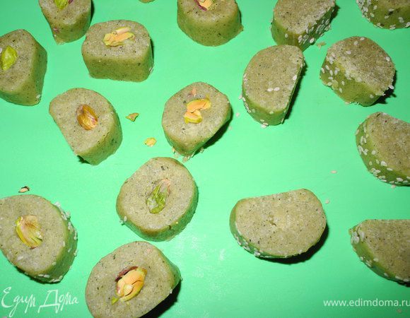 Утром достала колбаску из холодильника, разрезала на 2 части. Одну часть я обваляла в кунжуте. Разрезала колбаски на кружочки шириной 1,5-2 см. Воткнула в серединку по фисташке.  