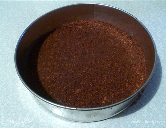 Для основы печенье измельчить в мелкую крошку. Добавить растопленное масло и перемешать.
Выложить в разъемную форму, застеленную пергаментной бумагой, утрамбовать.