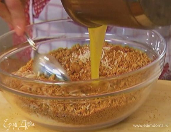 Соединить измельченное печенье с пармезаном, влить растопленное масло и все перемешать.
