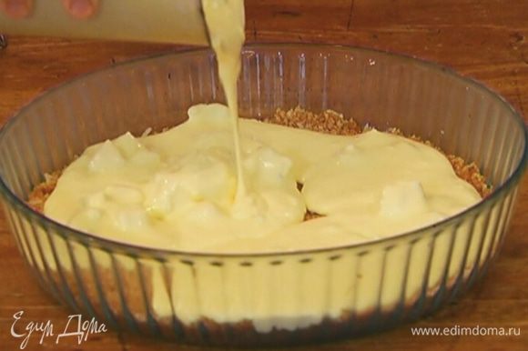 Вынуть корж из морозильника и вылить на него сырную начинку.
