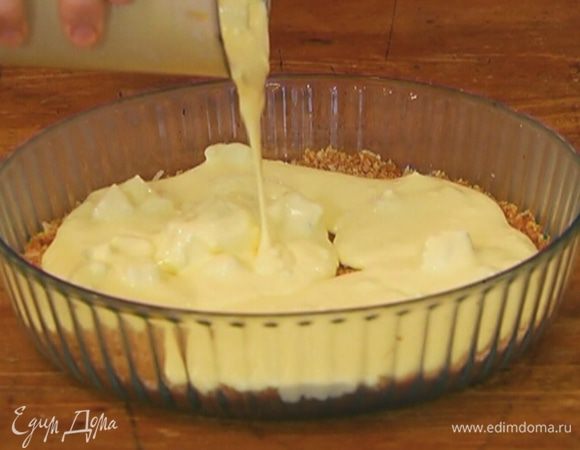 Вынуть корж из морозильника и вылить на него сырную начинку.