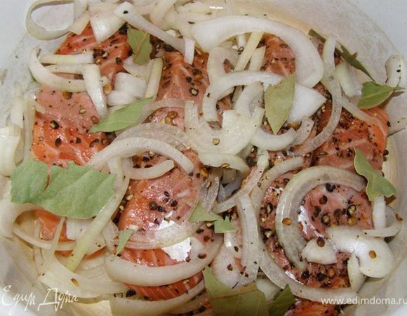 Порежем лук полукольцами.
Посыпем куски семги порезанным луком и лавровым листом, порванным на части