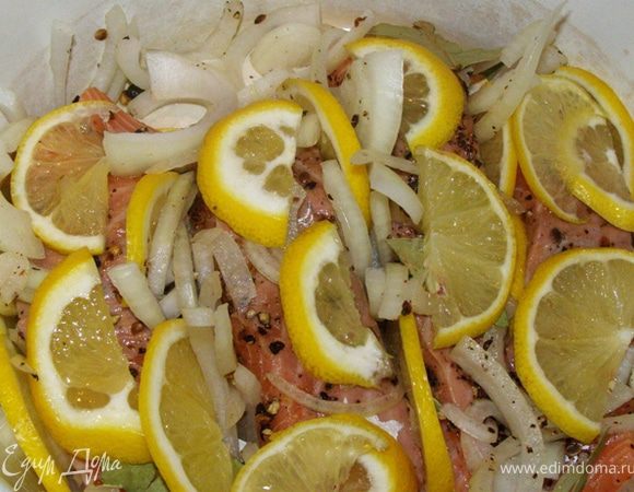 Тонко порежем 2/3 лимона кружками, затем перережем их пополам.
Выложим на семгу пластинки лимона, всовывая их между кусками семги
