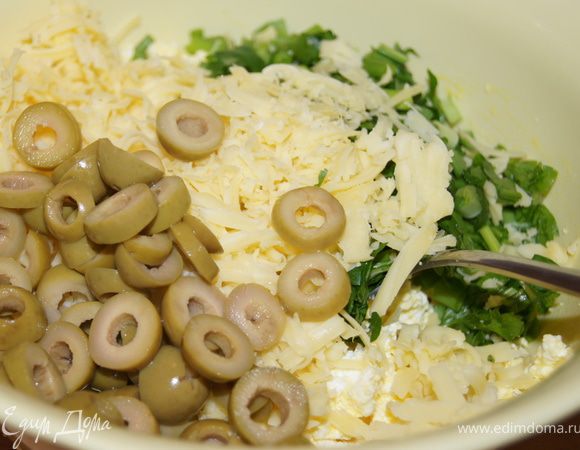 Сыр натереть на средней терке, оливки порезать колечками.