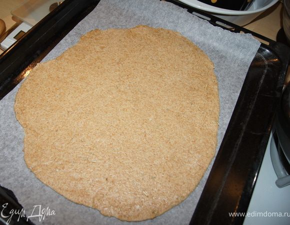 Духовку нагреть до 200С. Противень застелить пергаментом.
Тесто раскатать толщиной 0,5 см. Аккуратно переложить тесто на противень.