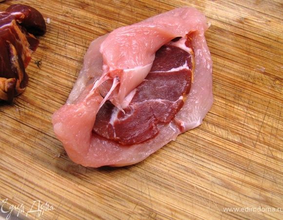 Положите ломтик копченого мяса в грудку и сложите грудку.