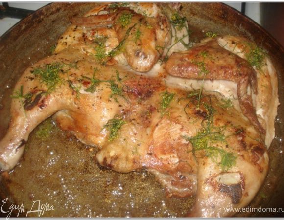 Кинзу вымыть, обсушить, мелко нарезать и смешать с рубленным чесноком. Цыпленка перевернуть, посыпать зеленью с чесноком и жарить еще 15 минут под гнетом.