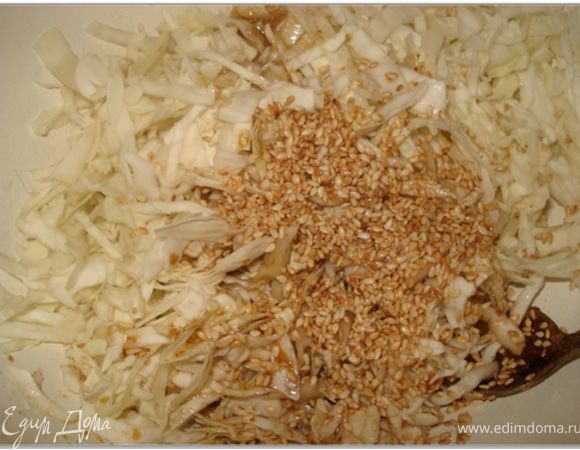 Капусту смешать с кунжутом и залить заправкой.
