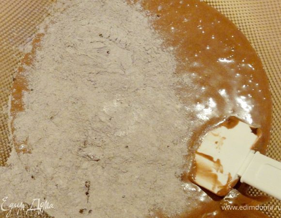 Смесь муки с какао-порошком постепенно добавить в шоколадно-желтковую массу.