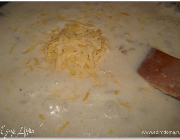 Добавить молоко, хорошо перемешать, чтобы не было комочков и добавить натертый на крупной терке сыр. Варить около 10 минут.