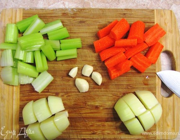 Почистите морковь и порежьте на крупные куски - по два сантиметра. Разрежьте каждый вдоль.
Обрежьте концы стеблей сельдерея и порежьте также по два сантиметра. Широкие куски - вдоль пополам.
Очистите лук и порежьте крупно на 8-12 частей (у меня получилось сначала пополам, потом еще раз пополам, потом каждую четвертинку на три части).
Овощи не надо резать мелко. Иначе потом вам трудно будет разделить капусту и остальные овощи.
Немного раздавите зубчики чеснока так, чтобы кожица лопнула. Теперь отрежьте попки и снимите кожицу. Она очень легко слезет.