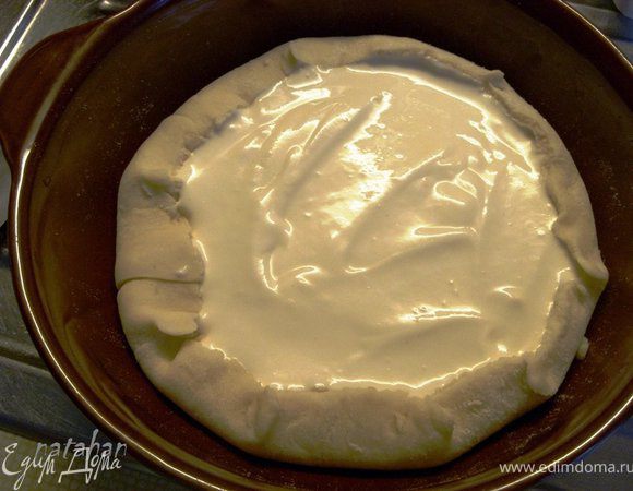 Приготовить форму для выпечки (у меня керамическая диаметром 20 см) - смазать её растительным маслом.
Достать тесто из холодильника и разделить его на две неравные части. Из большей части раскатать пласт толщиной 0.5 мм, вырезать круг (по большой тарелке) и выложить им форму изнутри. Вылить творожную начинку и излишки теста аккуратно завернуть вовнутрь - на начинку.