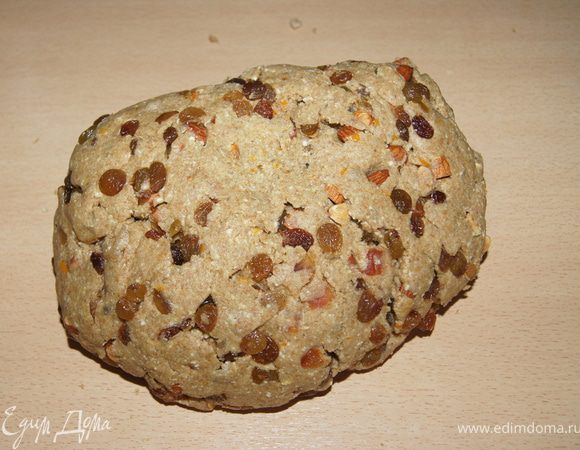 Творог смешать с сахарно-масляной массой. Добавить половину муки (предварительно смешав ее с разрыхлителем), орехи, сухофрукты. Руками перемешать. Тесто выложить на стол и постепенно досыпать муку, в конце добавить цедру апельсина. Замесить тесто.