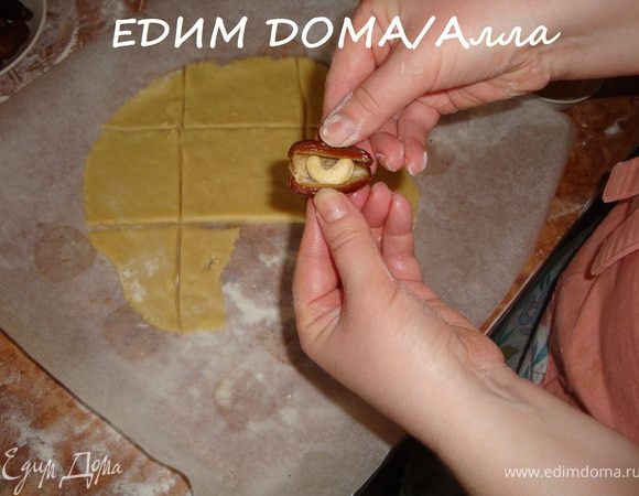 Я сначала раскатала кусочек охлажденного теста на рабочей поверхности и нарезала на кусочки. Но это оказалось совсем не обязательно. Итак, сказка начинается: берем финик (курагу), раскрываем по месту разреза и вкладываем орешек.