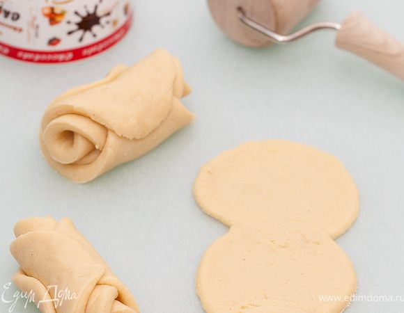 Раскатываем тесто и вырезаем из него кружочки с помощью чашки.
 