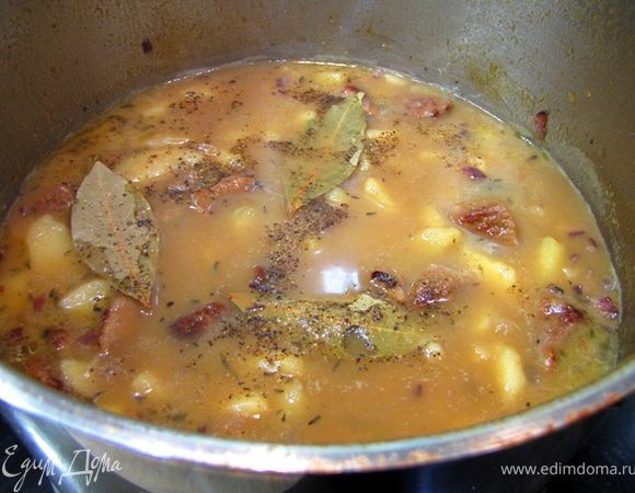 В конце блюдо посолите и добавьте обжаренный лук и три лавровых листа. Перемешайте (также встряхивая кастрюлю, чтобы картофель не сильно разломался) и оставьте в духовке еще на пять минут. Через пять минут достаньте кастрюлю, поперчите и положите мелко порезанную петрушку. Перемешайте и дайте постоять блюду 20 минут.
