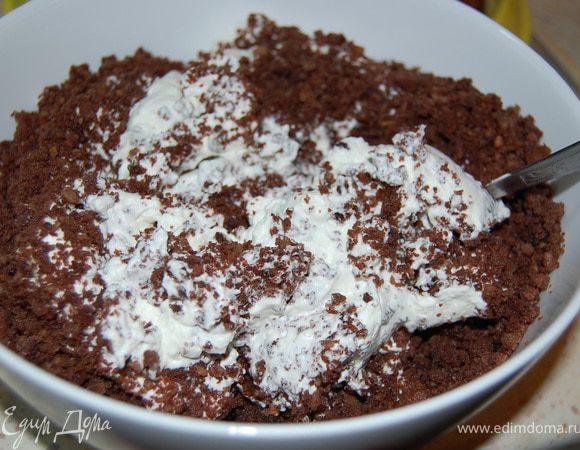 Взбить сливки с сахарной пудрой, добавить крошку.