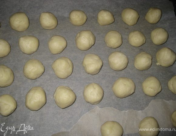 Через час отщипываем по кусочку теста, размером с грецкий орех, и скатываем в шарик. Выкладываем на застеленный пергаментом противинь.