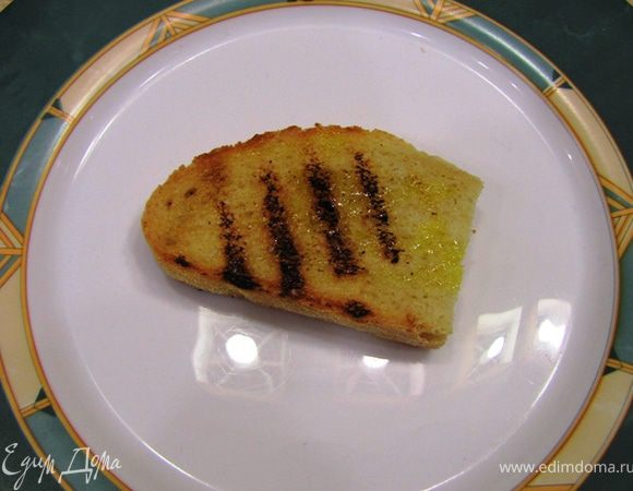 Возьмите одну кростини. Положите на отдельную тарелку, на которой вы будете формировать бутерброд.