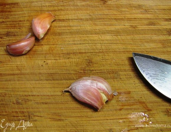Возьмите зубчики чеснока и плоской стороной ножа раздавите их. Теперь будет легко снять кожицу.