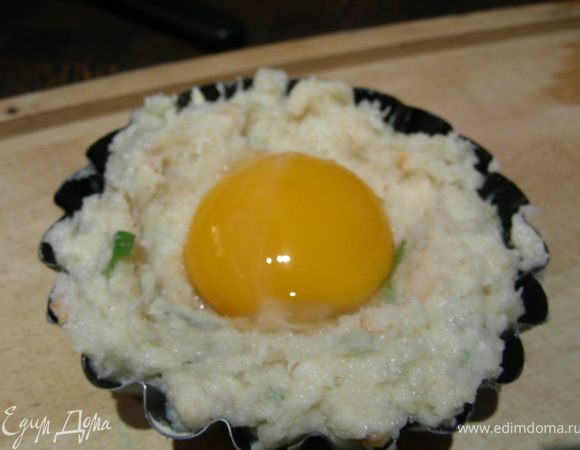 Делаем в смеси углубление и выливаем туда желток.