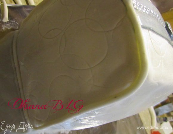 Покрыть бока кусочками мастики, по контуру прикрепить тоненький жгутик из мастики.