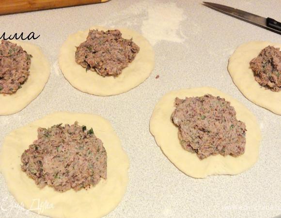 Тесто разделите на 5 частей. Очень важно, чтобы начинка и тесто были по размеру одинаковыми. Раскатайте каждый кусочек в маленькую лепешку и положите на нее начинку.
