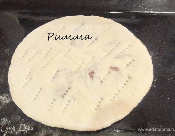 Затем раскатайте еще раз. Лепешки должны быть толщиной не более 1 см.
Смажьте противень раст. маслом. положите на нее лепешку и наколите вилкой верхний слой теста.