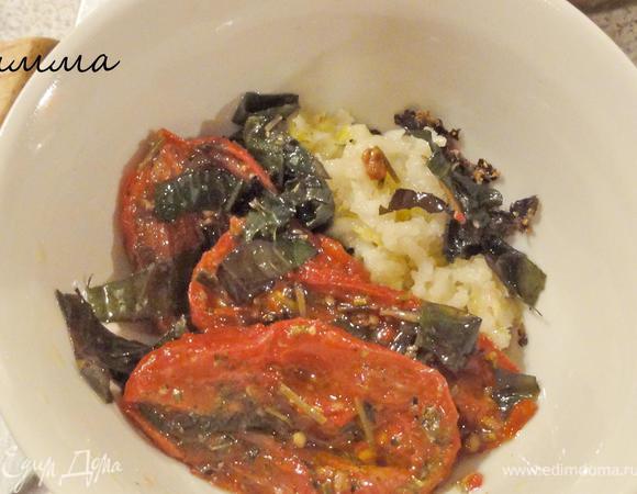 Чеснок выдавите с помощью пресса. Вяленые томаты очистите от кожицы. Положите рульку на доску кожей вниз. Смешайте специи с томатами и чесноком, хорошенько разотрите.