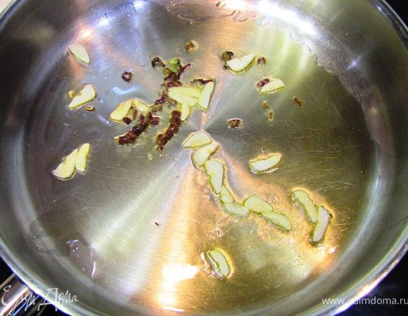 Разогрейте растительное масло в сковороде на среднем огне. Бросьте в сковороду чеснок и нарубленные стебли базилика.