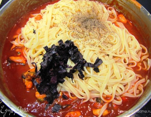 Посолите мидии. Откиньте макароны на дуршлаг. Обязательно оставьте немного воды, в которой варилась паста — около 4 ст. л. Положите пасту в мидии, влейте воду от пасты, хорошо перемешайте. Нагревайте около 1 минуты. Поперчите. Нарежьте листья базилика и добавьте в сковороду.