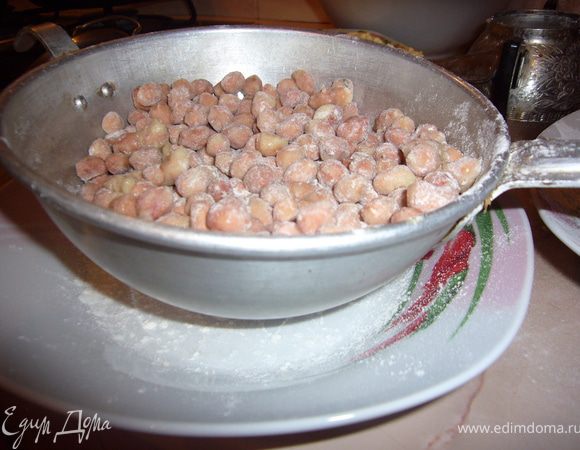 Посыпь орешки сахарной пудрой и кокосовой стружкой.