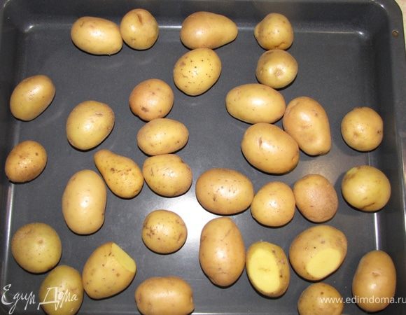 Обсушите картофель полотенцем и положите в глубокий противень.