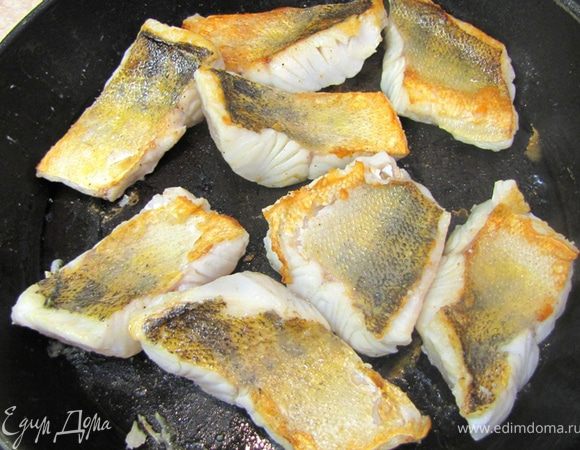 Аккуратно переверните рыбу и жарьте еще две минуты.