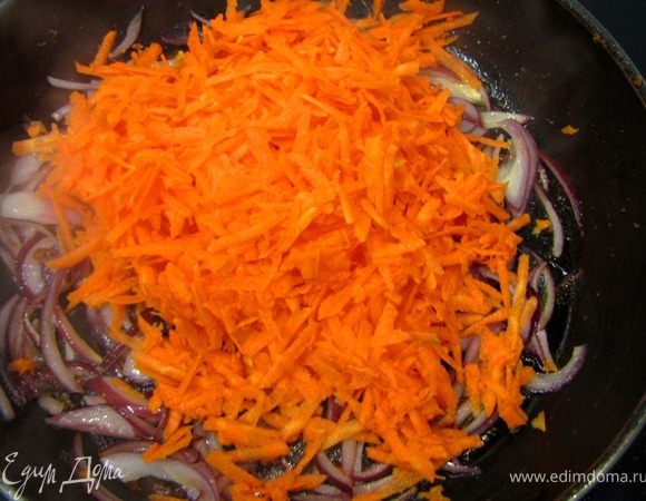 Натрите морковь на терке, предварительно почистив ее и помыв.
Долейте в сковороду еще две столовых ложки масла.
Начинайте обжаривать лук, часто помешивая.
Через три минуты положите туда же морковь.