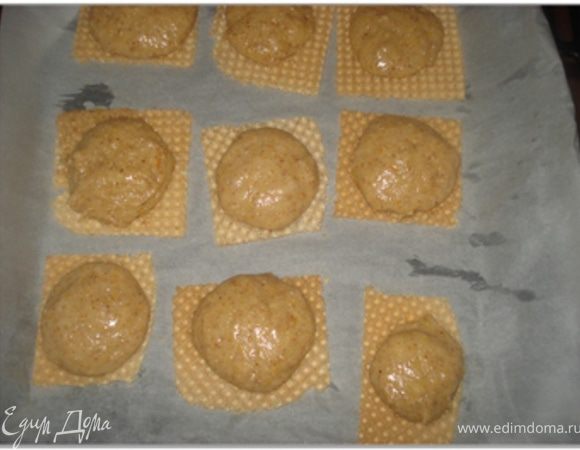 Противень застелить пергаментной бумагой и на него выложить вафли, нарезанные квадратами. Кондитерский мешок с широкой гладкой насадкой наполнить тестом и выдавить на вафли.