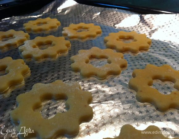 Духовку разогреть до 170С. Противень застелить фольгой. Тесто раскатать на посыпанной мукой поверхности до 0,4см, формочкой (обычной для печенья) вырезать фигурки и выложить их на противень. Второй формочкой (у меня для канапе) вырезать внутри печенья отверстие и вынуть его.