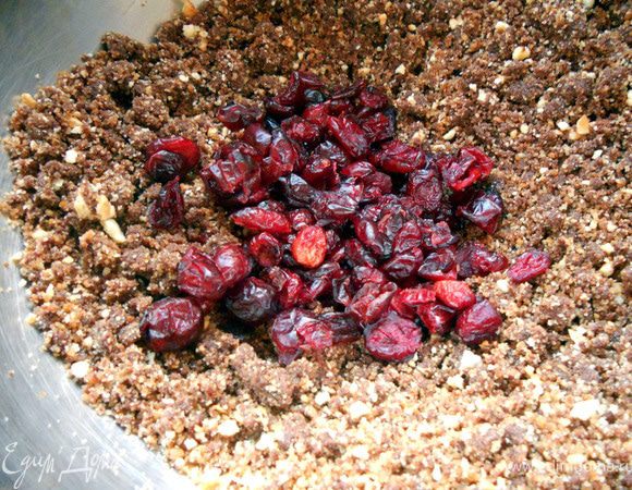 Добавить клюкву. Хорошо размешать, можно еще раз с помощью комбайна (буквально пара оборотов)- масса станет вязкой и послушной. Если крошка очень сухая, можно добавить немного (0,5-1 ст.л сливок/молока). 