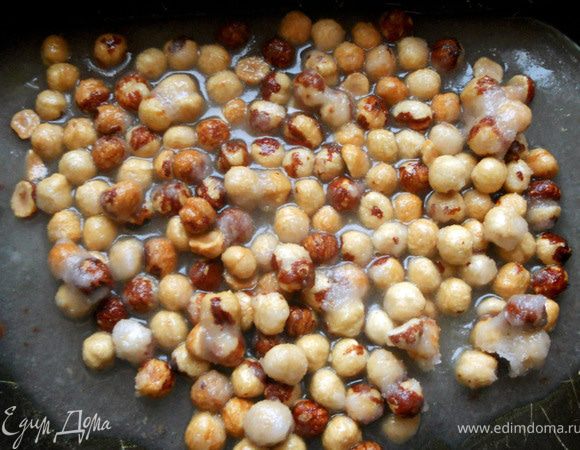 Форму/противень смазать оливковым маслом. Выложить карамель с фундуком, разровнять лопаткой. ***Вот тут случилось первое отступление от рецепта: карамель должна быть прозрачной (так и было в кастрюле), но в форме практически моментально засахарилась. Пересмотрел видео, проверил текст переводчика - все верно. Подумал, что возможно вместо сахарной пудры Оливер использовал мелкий сахар...или что-то с временем варки не так...***. Оставить на 30 минут. 