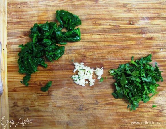 Обязательно выжмите листья от лишней воды.
Мелко рубим базилик (у меня кинза, но я советую базилик. Он намного больше подходит), пол зубчика чеснока.
Довольно крупно рубим листья шпината.
Если у вас мороженный шпинат, бланшировать его уже не надо. Просто разморозьте и порубите.