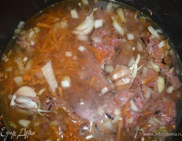 добавляем специи, солим и заливаем водой. Все ингредиенты необходимо перемешать, сверху уложить зубчики чеснока. 