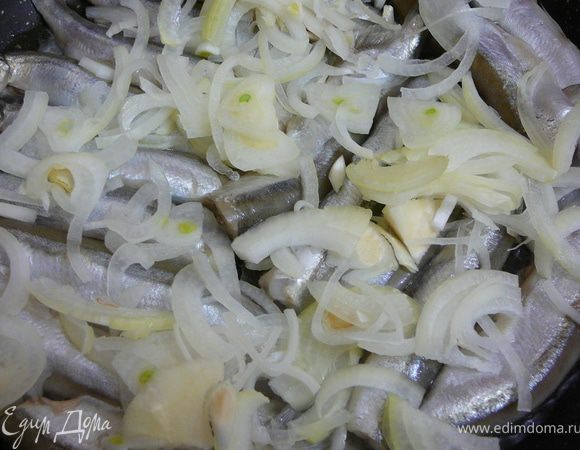 Поверх мойвы выложить лук.