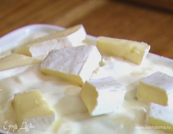 Выложить на запеканку сметану, сверху разложить кусочки сыра.