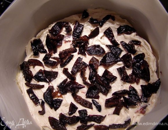  Слегка смазываем корж кремом, выкладываем половину чернослива. 
Затем 1/3 крема, накрываем вторым коржом и слегка придавливаем.
