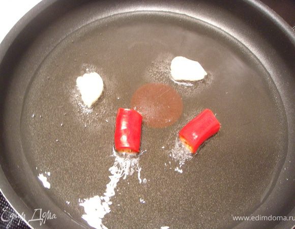 В сковороде разогреть оливковое масло. Обжарить на нем 2 раздавленных зубчика чеснока и 2 кусочка перца чили. Вынуть приправы.