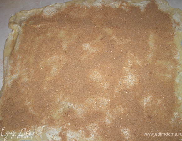 Поднявшеееся тесто делим на 2 части. Берем одну часть и раскатываем в большой прямоугольник, чем тоньше, тем больше будет завитков далее. Смазываем тесто половиной сливочного масла(масло должно быть довольно мягким), посыпаем корицей с сахаром.