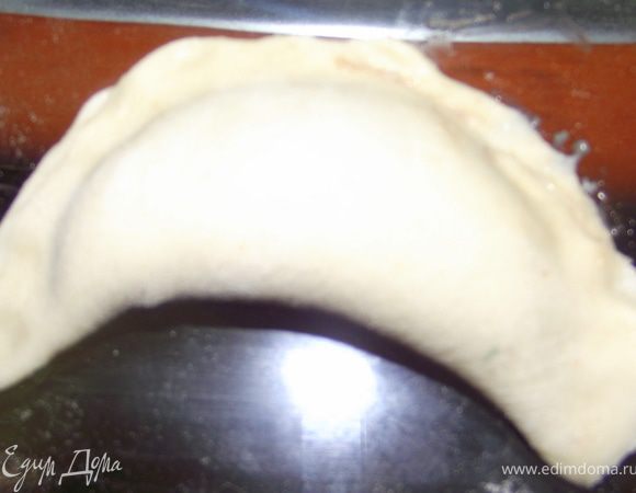 Свободной половиной накройте и закрепите пельмени по краю. Для лучшей клейкости края можно совсем слегка намочить.