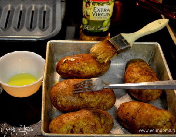 Вымыть картофель,обсушить. Проткнуть вилкой каждый картофель для лучшего запекания.Обмазать раст.маслом.Выложить на противень.
